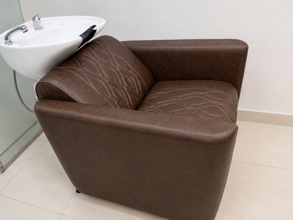 Quilted salon chair attached to a ceramic shampoo bowl